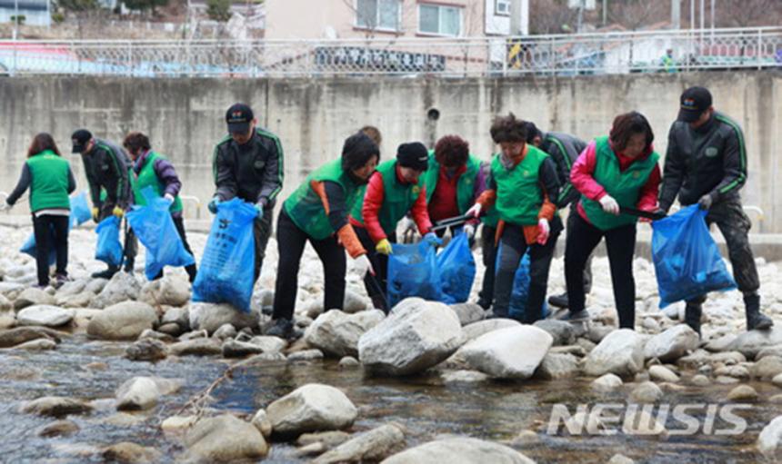 육군 제 27사단 장병들이 세계 물의 날을 맞아 21일 지역주민들과 함께 강원 화천군 사내면 하천 및 계곡 일대에 방치되고 있는 폐기물과 폐농사 자재 등을 수거하는 활동을 펼쳤다.2018.03.21. / 뉴시스 제공