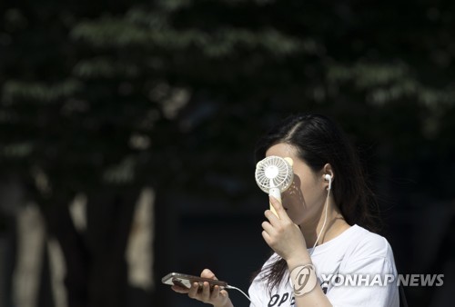 한 시민이 휴대용 선풍기로 폭염을 피하고 있다. [연합뉴스 자료사진]