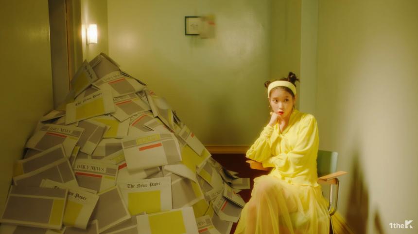 아이유 ‘삐삐’의 뮤직비디오에는 경고를 뜻하는 노란색과 가십을 의미하는 종이신문이 많이 등장한다 / 아이유  ‘삐삐’ 뮤직비디오 영상 캡처