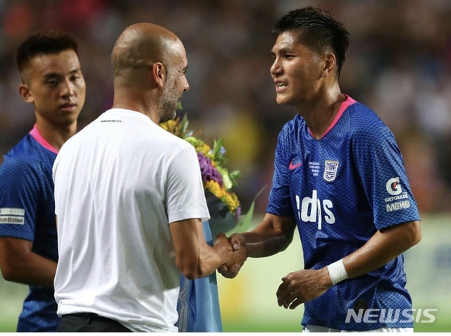 축구 국가대표 출신 김동진(홍콩 키치)이 24일 홈구장인 홍콩 스타디움에서 열린 맨체스터 시티와의 프레시즌 친선 경기를 통해 은퇴식을 가졌다. 펩 과르디올라(왼쪽) 맨시티 감독으로부터 은퇴 축하를 받고 있다. (사진 = DJ매니지먼트 제공)