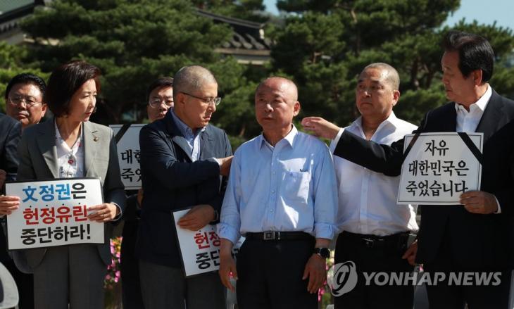 자유한국당 황교안 대표(왼쪽 두번째)가 18일 오전 서울 청와대 분수대 앞에서 이주영 국회부의장 어깨의 머리카락을 털어내고 있다. 이 부의장 오른쪽은 이날 함께 삭발한 심재철 의원. 2019.9.18 / 연합뉴스