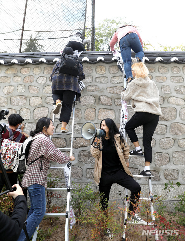 한국대학생진보연합이 18일 오후 서울 중구 주한 미국대사관저에서 방위비분담금 협상 관련 기습 농성을 하기 위해 담벼락을 넘고 있다. 2019.10.18. / 뉴시스