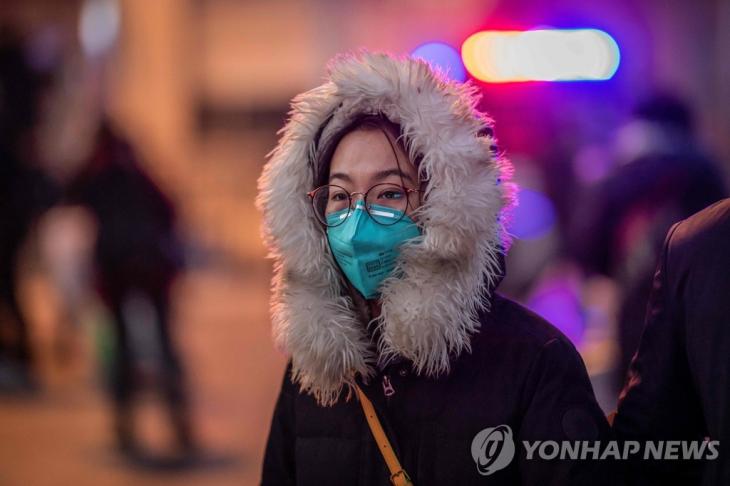 중국에서 신종 코로나바이러스가 일으키는 '우한 폐렴'의 사망자가 급증하는 가운데 마스크를 착용한 한 여성이 22일 베이징 기차역 앞 거리를 걸어가고 있다. / 연합뉴스