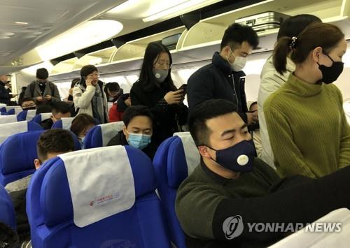 마스크 쓴 우한행 여객기 승객들. 지난 21일 중국 상하이(上海)를 출발해 우한(武漢)으로 향하는 항공기에 탄 승객들이 신종 코로나바이러스 감염을 막고자 마스크를 쓰고 있다. [연합뉴스 자료사진]