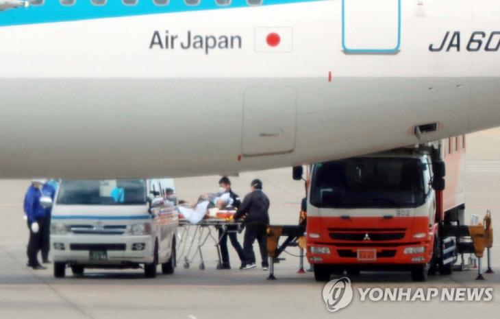 신종 코로나바이러스가 발발한 중국 우한 거주 일본인들을 태우고 31일 일본 도쿄 하네다 공항에 착륙한 3차 전세기에서 환자 1명이 들것에 실려 옮겨지고 있다. / 연합뉴스