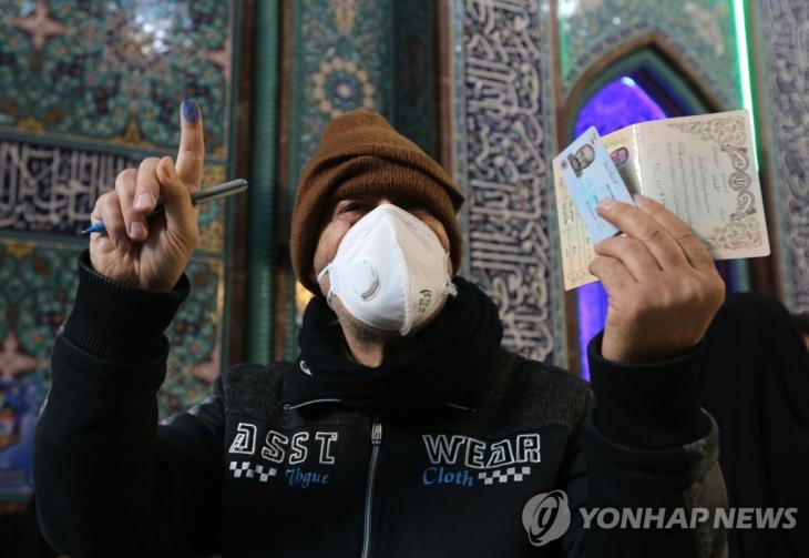 이란 총선이 실시된 21일(현지시간) 수도 테헤란에서 한 유권자가 마스크를 쓰고 투표에 참가하고 있다. 이란에서는 그동안 5명이 신종 코로나바이러스 감염증(코로나19) 확진자로 진단돼 이중 2명이 숨진 것으로 알려졌다. / 연합뉴스