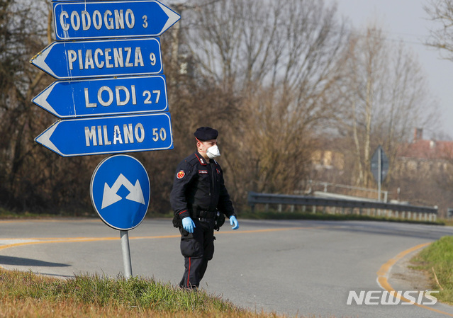 24일(현지시간) 이탈리아 밀라노 남동쪽 약 50km 떨어진 코도뇨의 한 교차로에서 이탈리아 경관이 검문하고 있다. 이탈리아는 24일 기준 신종 코로나바이러스 감염증 7번째 사망자가 나오고 확진자 수는 최소 229명으로 늘었다. 2020.02.25. / 뉴시스