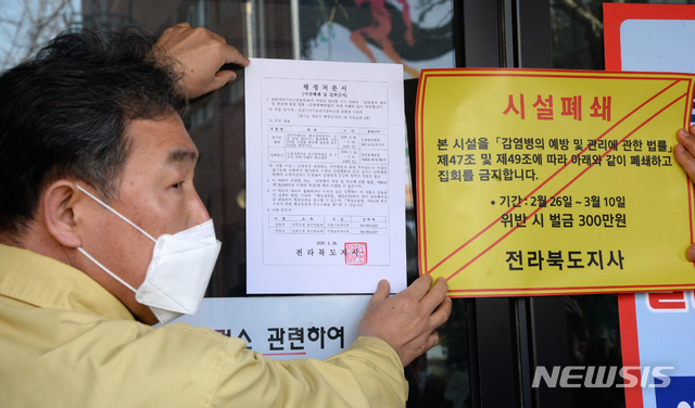 26일 전북 전주시 신천지 하늘문화센터에서 전라북도 관계자들이 '감염병 예방 및 관리에 관한 법률'의 행정명령을 집행해 시설을 폐쇄하고 스티커를 붙이고 있다. 2020.02.26. / 뉴시스