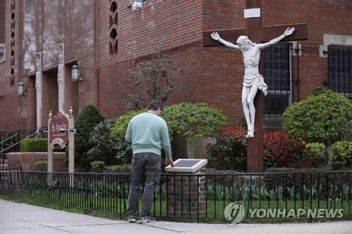 한 남자가 10일(현지시간) 미 뉴욕 브룩클린의 문 닫은 교회 밖에서 기도하고 있다. [로이터=연합뉴스]