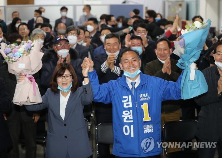 전남 목포에 출마한 더불어민주당 김원이 후보가 15일 오후 전남 목포시 선거캠프에서 당선이 확실시되자 꽃다발을 들고 환호하고 있다. 2020.4.15 / 연합뉴스