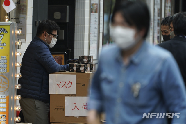 일본 도쿄에서 지난 22일 마스크를 착용한 남성이 '마스크 입고'라고 적힌 종이를 박스에 붙이고는 입고 된 마스크를 꺼내 놓고 있다. 2020.04.23. [도쿄=AP/뉴시스]