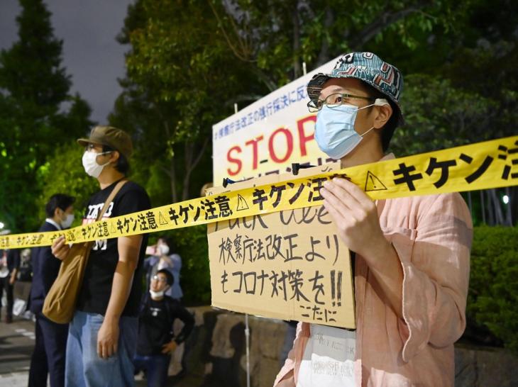 일본 검찰청법 개정에 반대하는 시위. 아베 신조 정권이 추진하는 검찰청법 개정에 반대하는 시민이 지난 15일 오후 일본 국회 앞에서 "검찰청법 개정보다는 코로나 대책을"이라고 쓴 종이를 들고 시위를 하고 있다. 2020.5.18 / 연합뉴스