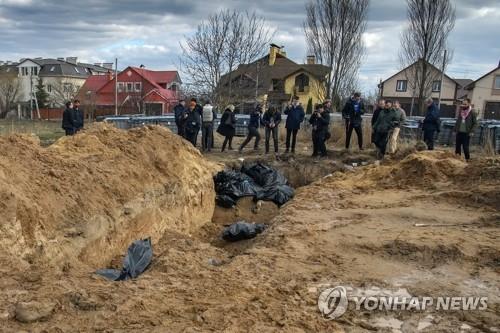 민간인 집단 매장지 살펴보는 우크라 부차 주민들(부차 로이터=연합뉴스) 우크라이나 수도 키이우(키예프) 북쪽 소도시 부차에서 4일(현지시간) 주민들이 러시아군에 살해된 것으로 추정되는 민간인 집단 매장지를 살펴보고 있다. 러시아군이 한 달 넘게 점령했다가 철수한 이 지역에서는 학살된 의혹이 짙은 민간인 시신이 잇따라 발견되고 있다. 2022.4.5