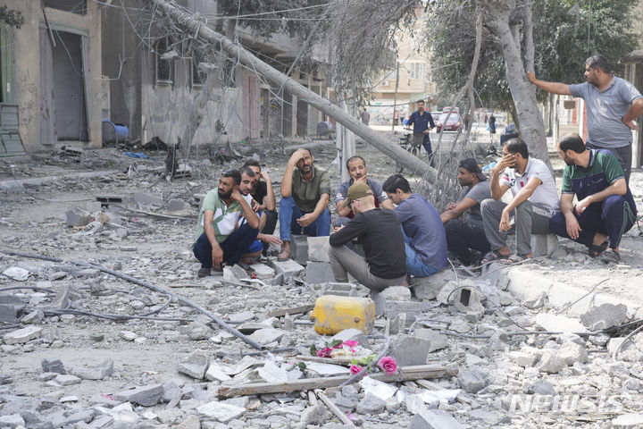 [AP/뉴시스] 16일 가자 지구 중부의 누세이라트 난민 캠프에서 이스라엘 공습을 당한 주민들이 말없이 앉아 있다
