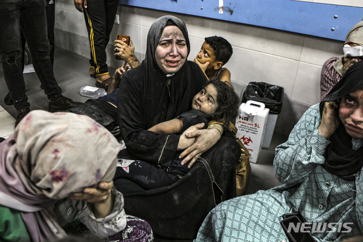 [가자시티=AP/뉴시스]이스라엘이 책임을 부인하고 있는 가자지구 알아흘리 아라비 침례 병원에 대한 17일(현지시간) 치명적인 공격에 대해 국제적인 비난이 빗발치고 있다. 사진은 이날 알 아흘리 병원 복도에 앉은 한 팔레스타인이 통곡하고 있는 모습.  2023.10.18.