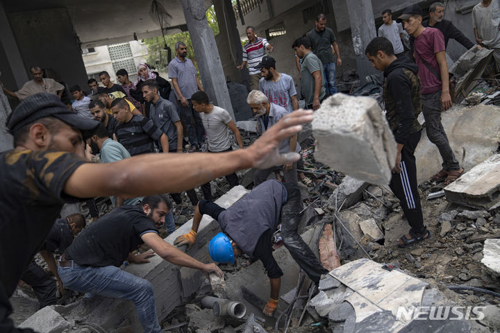 [가자지구=AP/뉴시스] 17일(현지시각) 가자지구 라파 난민캠프에서 팔레스타인 주민들이 이스라엘의 공습으로 파괴된 건물 잔해 속 생존자를 찾고 있다. 2023.10.18.