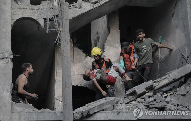 가자지구 건물 잔해 속에서 아이 구조하는 대원들[EPA=연합뉴스]