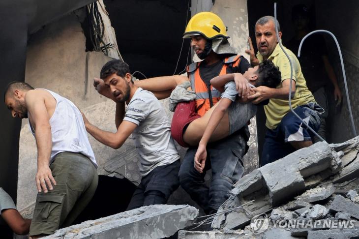 (칸유니스 AFP=연합뉴스) 팔레스타인 무장 정파 하마스와 이스라엘 간 무력 충돌이 계속되는 가운데 19일(현지시간) 이스라엘 공습으로 파손된 가자지구 칸 유니스 건물에서 시민방위대원과 주민들이 생존자를 구조하고 있다. 지난 7일 하마스가 이스라엘을 공격해 교전이 벌어진 뒤 양측 사망자는 4천800여명에 달한다. 2023.10.19