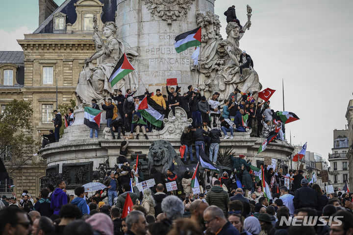 [파리=AP/뉴시스] 22일(현지시각) 프랑스 파리에서 열린 팔레스타인-이스라엘의 지속적 평화를 위한 집회에서 참석자들이 팔레스타인 깃발을 흔들면서 휴전 및 가자 지구 폭격 중단을 요구하고 있다. 2023.10.23.