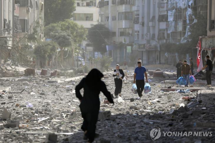 이스라엘군의 공습으로 잿더미로 변한 가자시티에서 사람들이 피란길에 오르고 있다.[AP 연합뉴스 자료사진]
