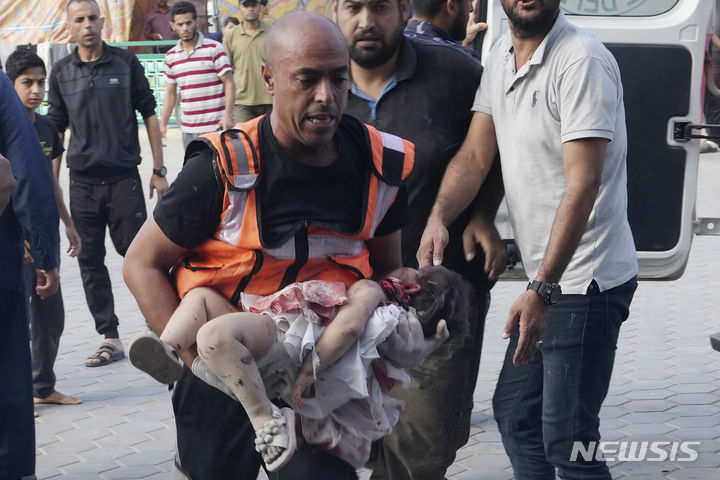 [가자지구=AP/뉴시스] 지난달 31일(현지시각) 이스라엘의 가자지구 폭격으로 다친 팔레스타인 어린이가 구급대원에 안겨 데이르 알발라에 있는 알 아크사 병원에 도착하고 있다. 가자 지구가 어린이들의 무덤이 되고 있다. 2023.11.03.